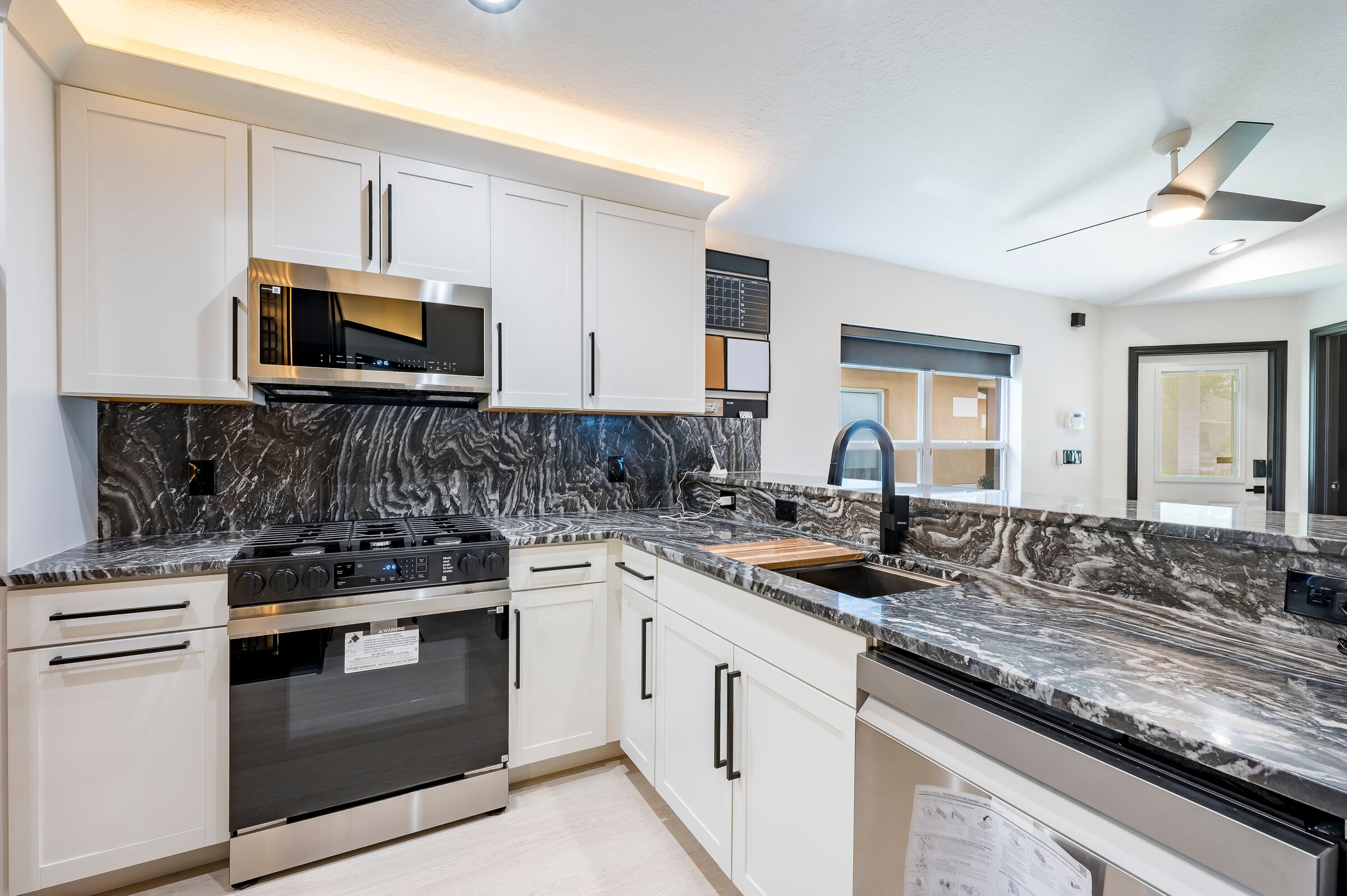 Kitchen range and countertop at 7522 Oxford Garden Circle in Apollo Beach — gas range, marble countertops, and LED cove lighting